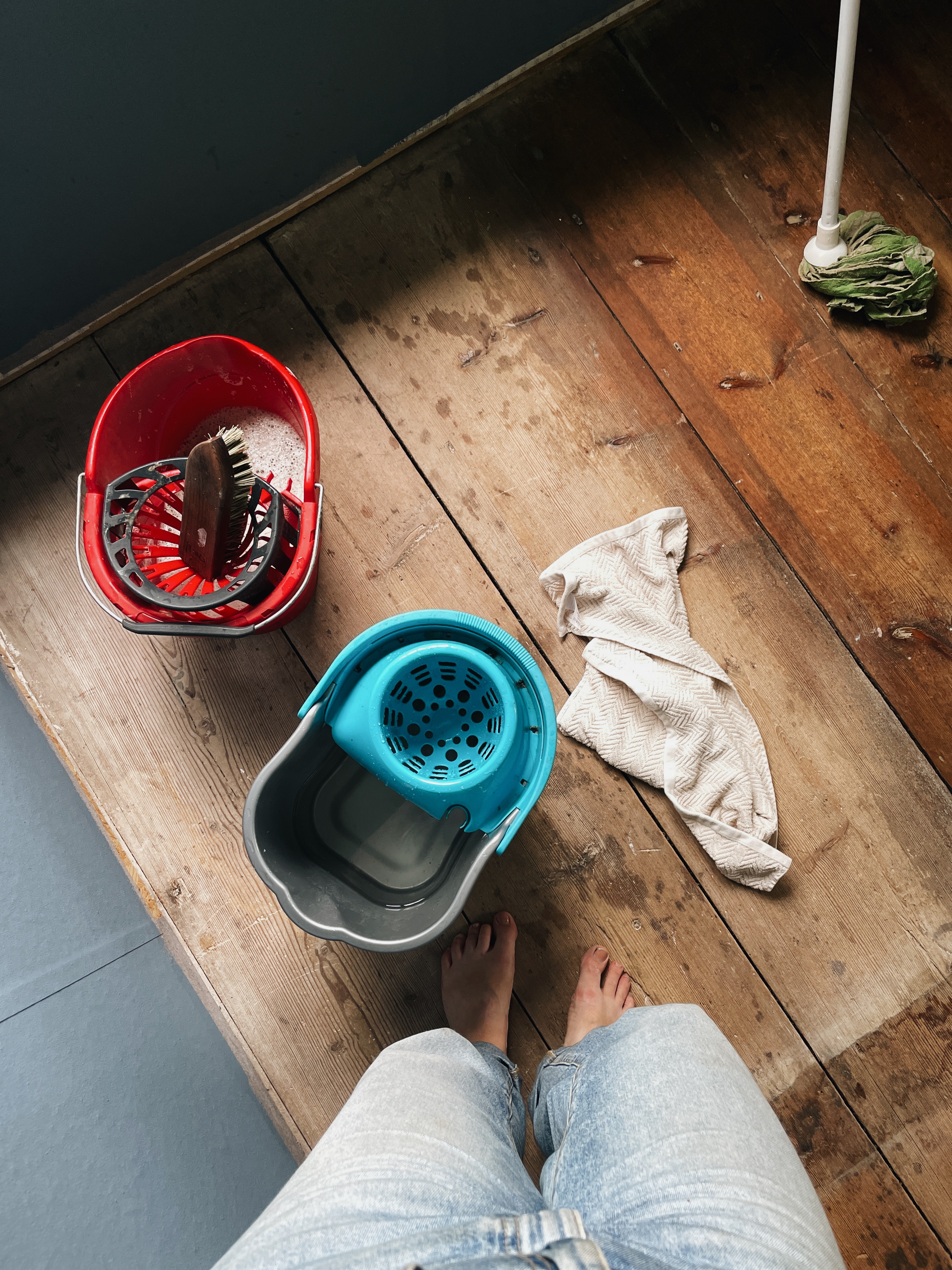 Uppifrån-perspektiv med hinkar och borste på golvet